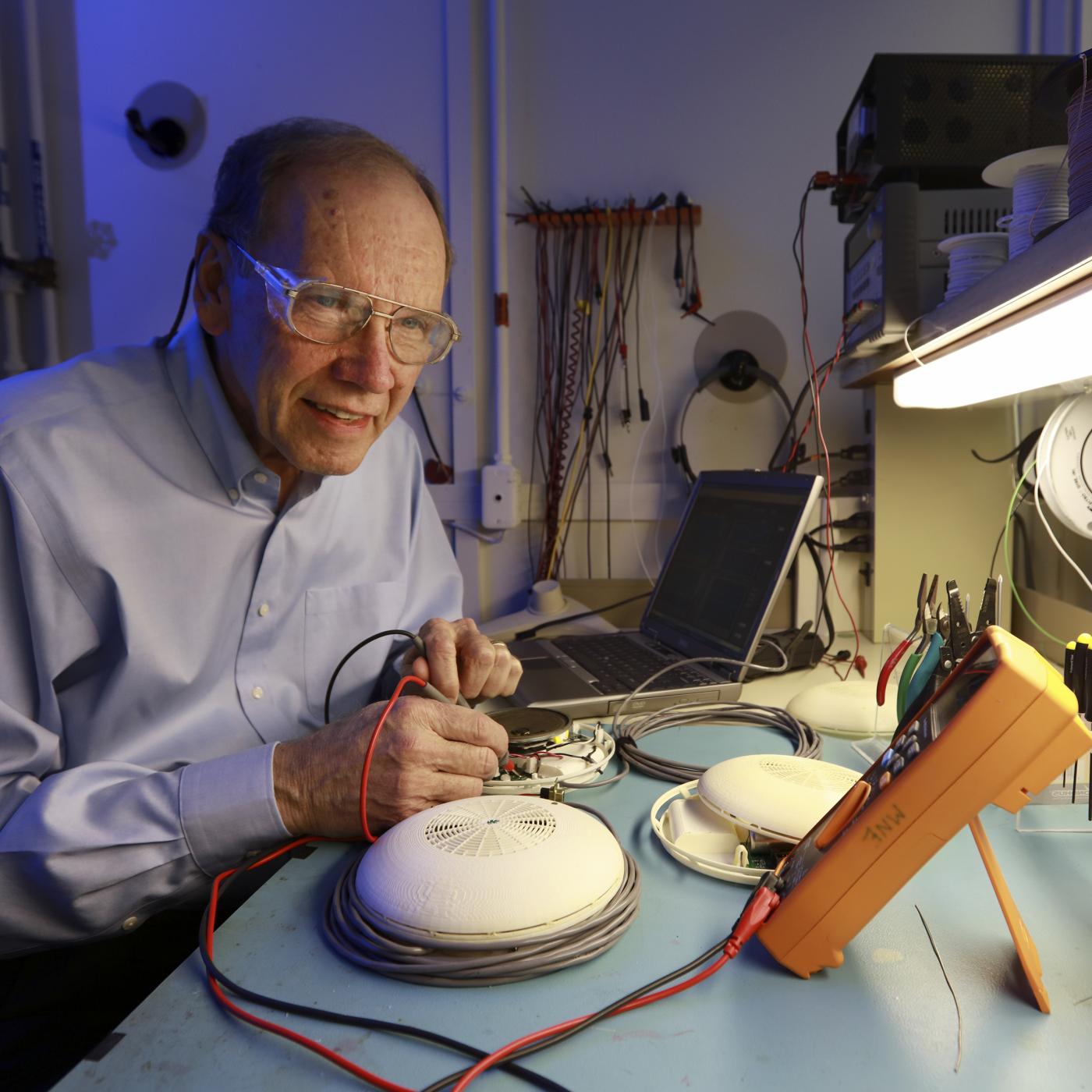 researcher in a button-down shirt works with electrical measurement equipment