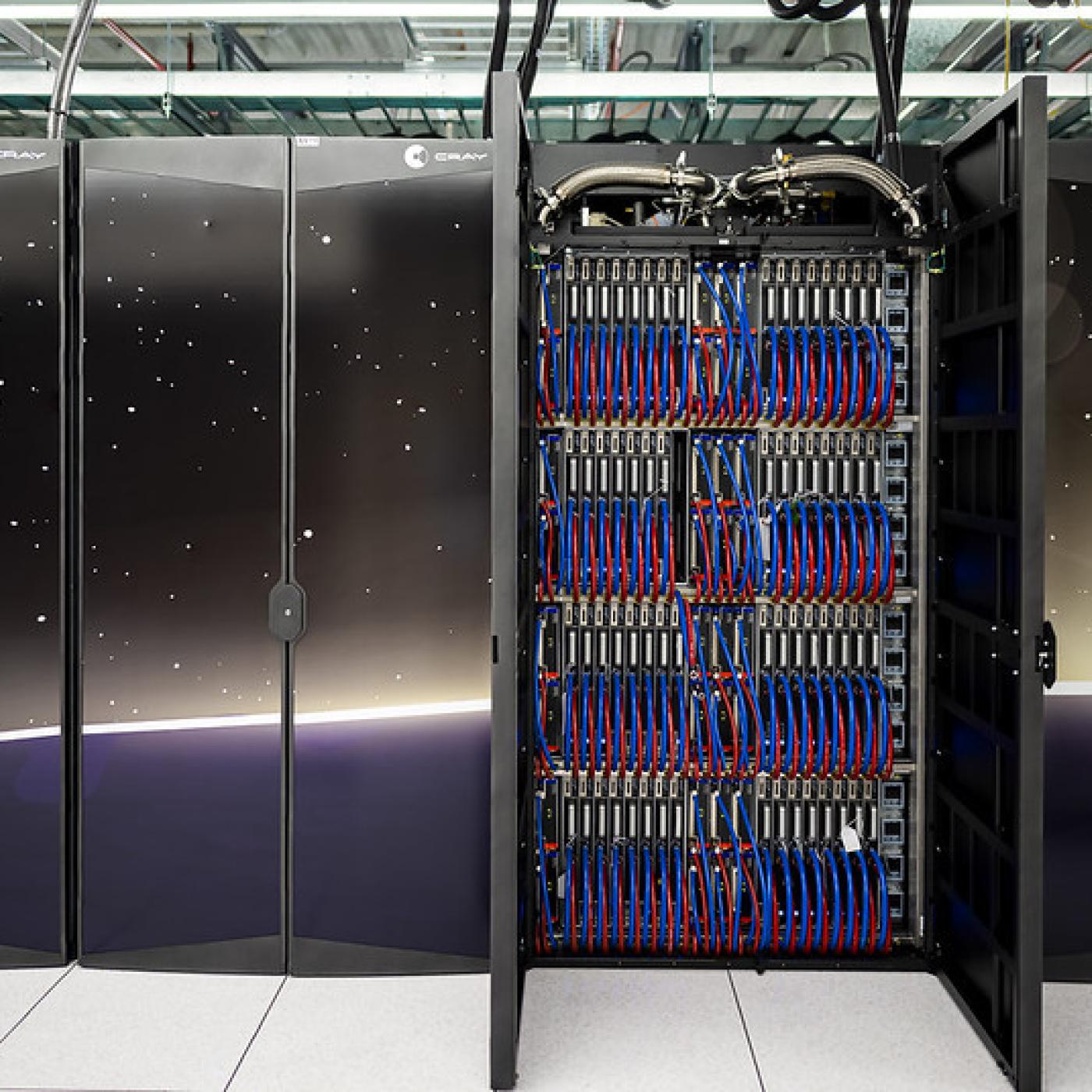 Two cabinets of ORNL's Frontier supercomputer are open to show the blue and red cords on the inside. 