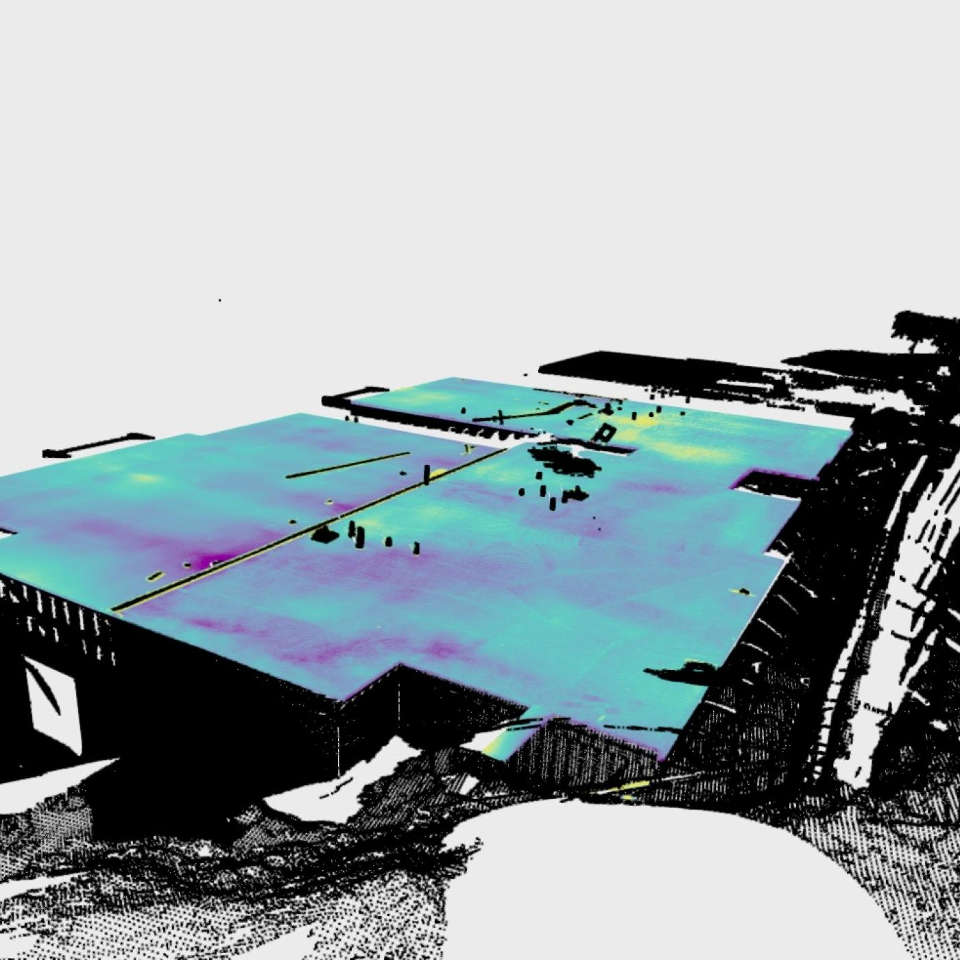 A color-enhanced 3D laser scan of a large concrete slab in a housing development, showing surface variations in shades of blue, green, yellow, and purple. Surrounding structures and terrain are rendered in black and white. The image was captured using the FLAT tool’s 360-degree scanning technology.