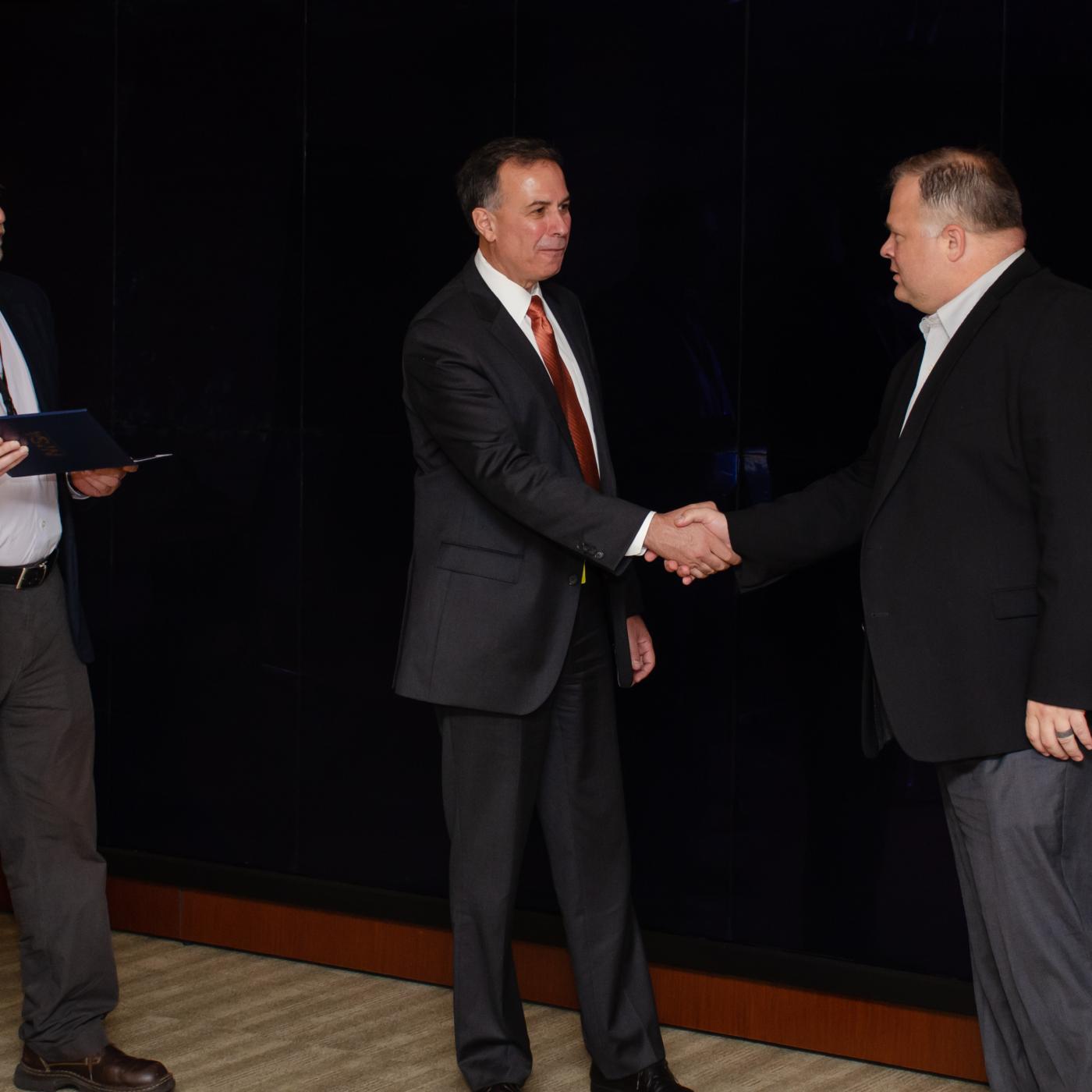 Dr. Dimitri Kusnezov (center), assisted by Edmon Begoli (left), thanks Kris Torgerson, ORNL chief information and privacy officer, for ITSD’s efforts on the MVP-CHAMPION program.