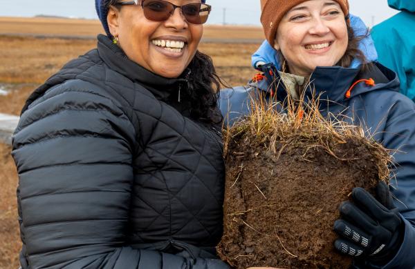 Dr. Asmeret Berhe and Dr. Colleen Iversen holding a large piece of permafrost