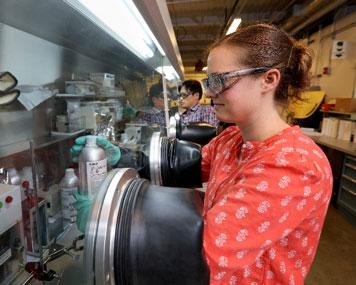 Researcher Marissa Wood assembles prototype coin cells in an Ar glove box for studying electrode manufacturing process improvements 