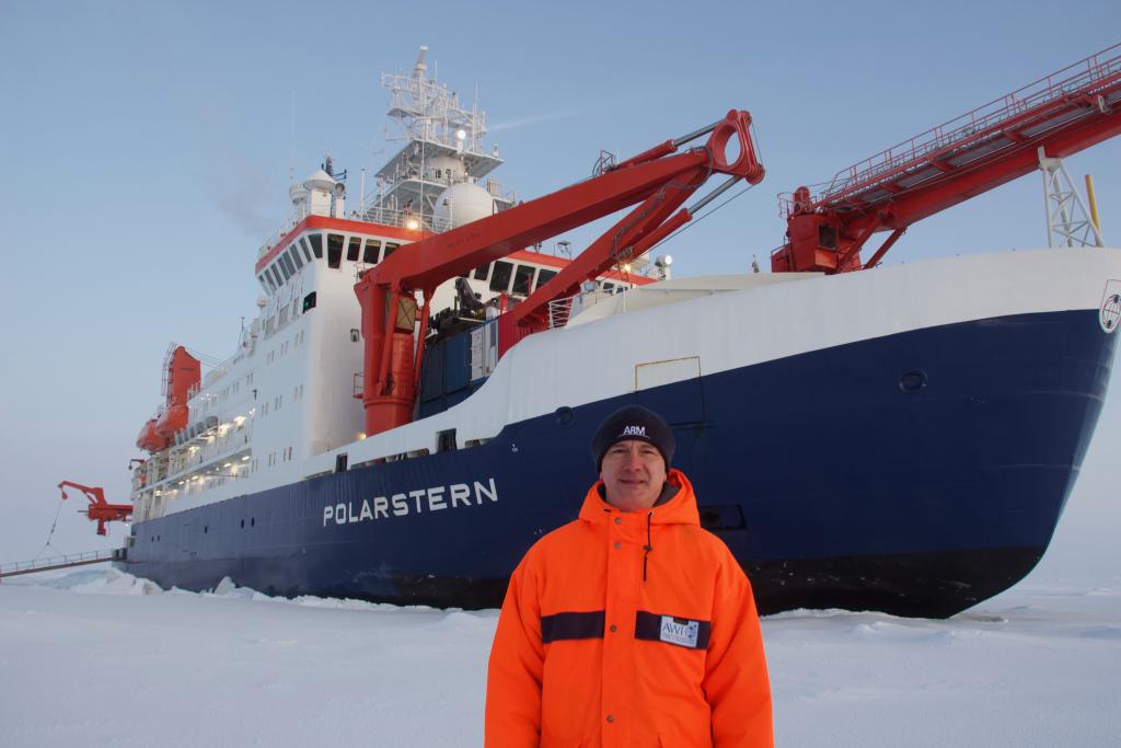 Misha Krassovski, a computer scientist at Oak Ridge National Laboratory, stands in front of the Polarstern, a 400-foot long German icebreaker. Krassovski lived aboard the Polarstern during the first leg of the MOSAiC mission, the largest polar expedition ever. Credit: Misha Krassovski/Oak Ridge National Laboratory, U.S. Dept. of Energy