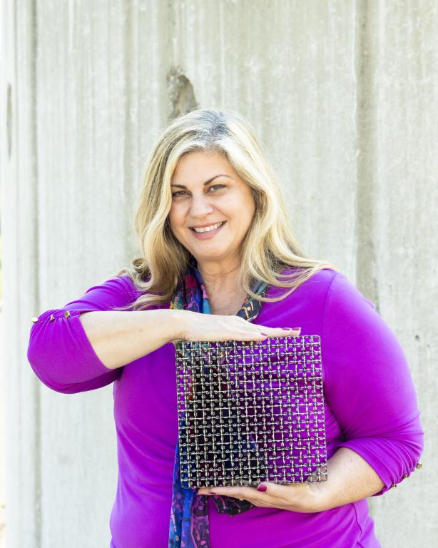 Rose Montgomery holds a metal grid used in nuclear fuel assemblies to position the fuel rods in canisters. Credit: Genevieve Martin/Oak Ridge National Laboratory