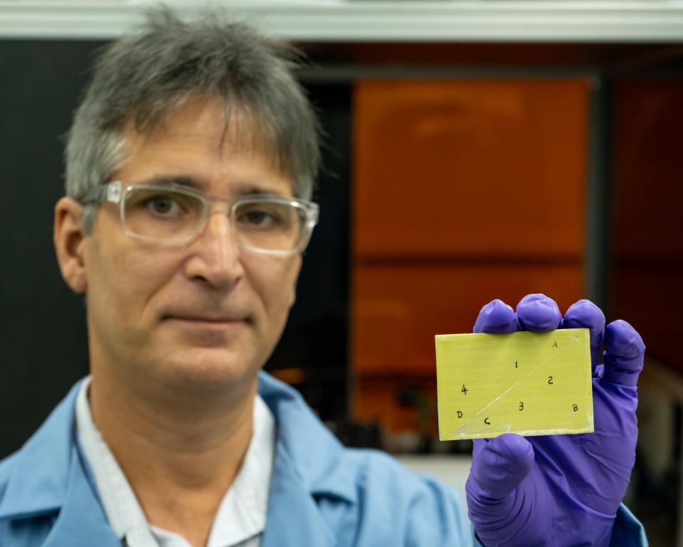 Adrian Sabau holds a primer-coated specimen, which was pretreated with a laser-interference structuring technique and shows coating adhesion. Credit: Carlos Jones/ORNL, U.S. Dept. of Energy