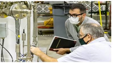 Ezekial “Zeke” Unterberg (left) and Chuck Kessel (right) check the helium flow loop experiment that is part of the lab’s LDRD fusion initiative for FY 2022.