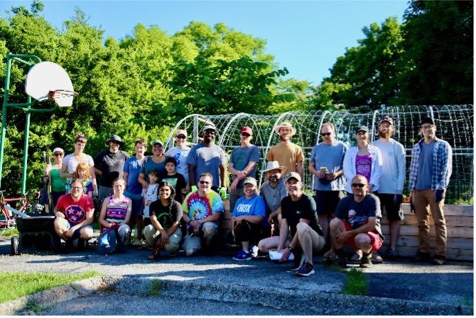 ORNL staff poses for a group photo at Socially Equal Energy Efficient Development (SEEED) in East Knoxville. Employees volunteered to help the nonprofit cut brush, clean up compost piles, and build garden beds. 