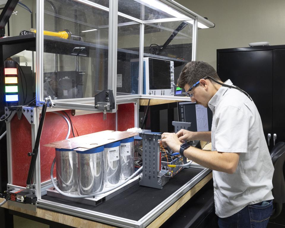 Researcher working on wiring a device on a workbench