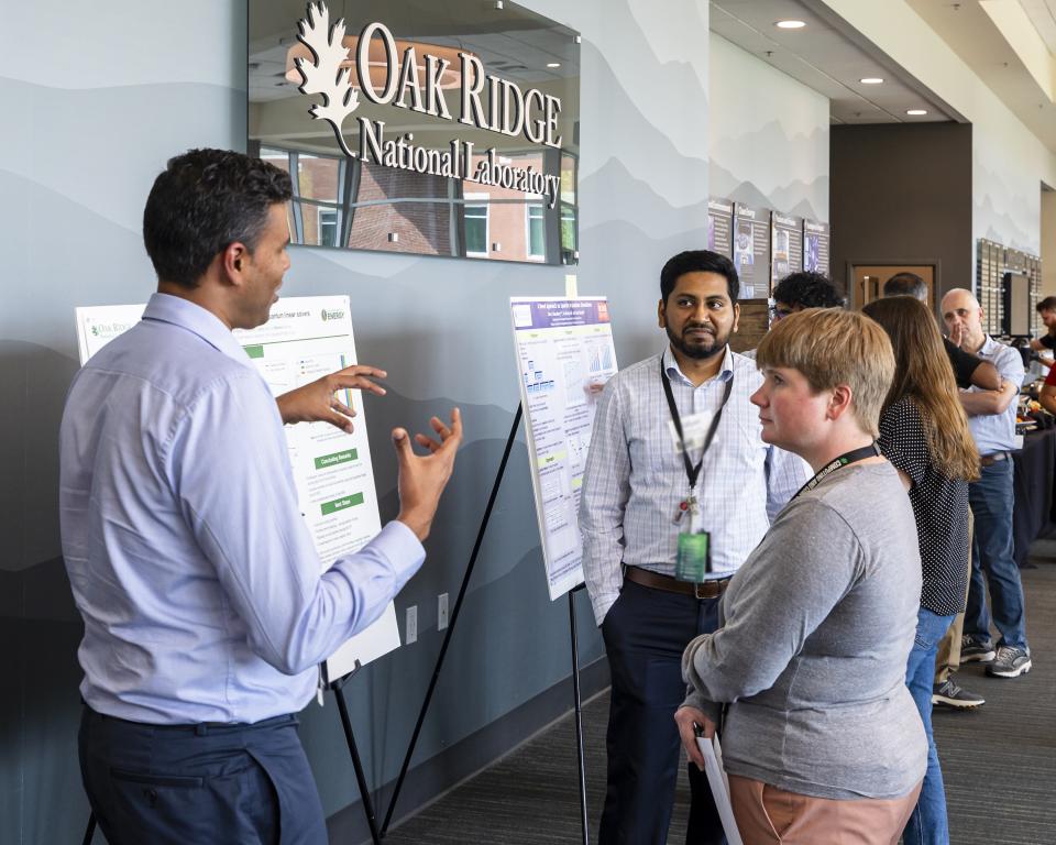 A group of people discussing a poster at a poster session.