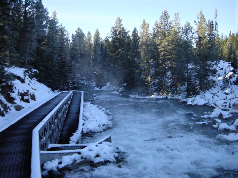 Snowy bridge next to waterway
