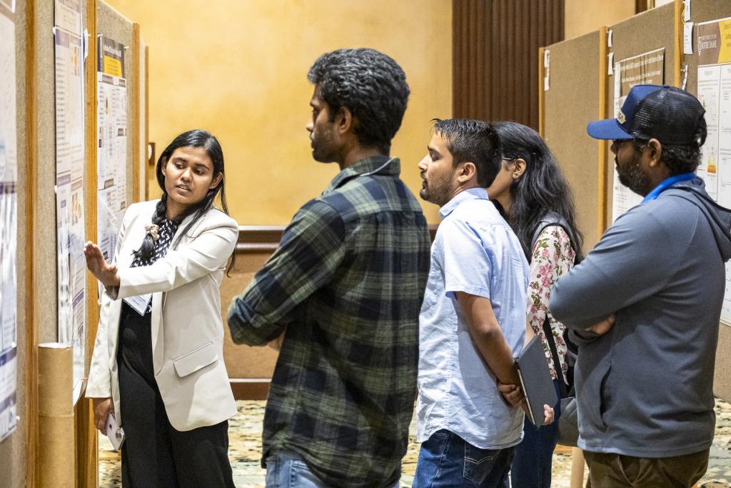 Chathuddasie Amarasinghe explains her research poster, “Using Microfluidic Mother Machine Devices to Study the Correlated Dynamics of Ribosomes and Chromosomes in Escherichia Coli.” Credit: Carlos Jones/ORNL, U.S. Dept. of Energy