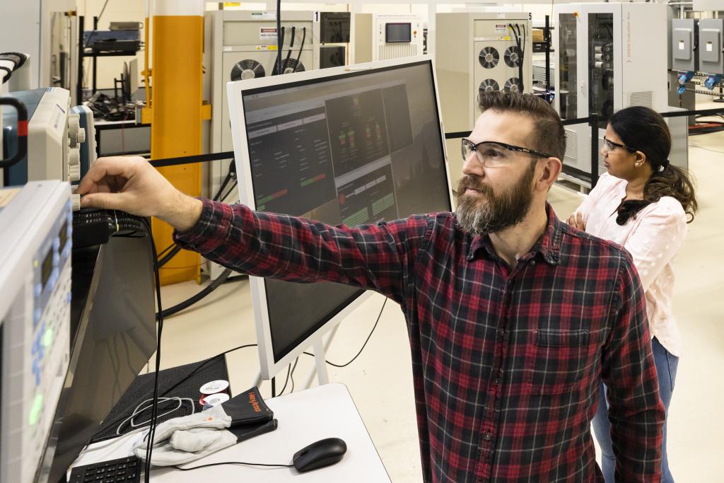 Steven Campbell works with Radha Krishna-Moorthy on a grid architecture suite in ORNL’s Grid Research Integration and Deployment Center. Credit: Carlos Jones/ORNL, U.S. Dept. of Energy