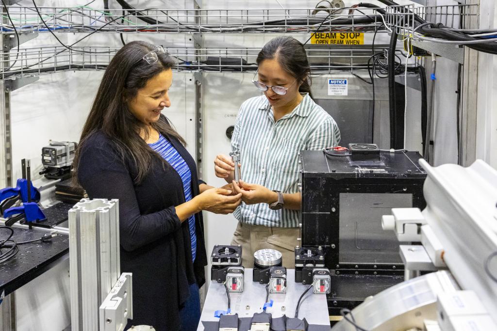 Nidia Gallego and Jisue Moon standing together looking at component