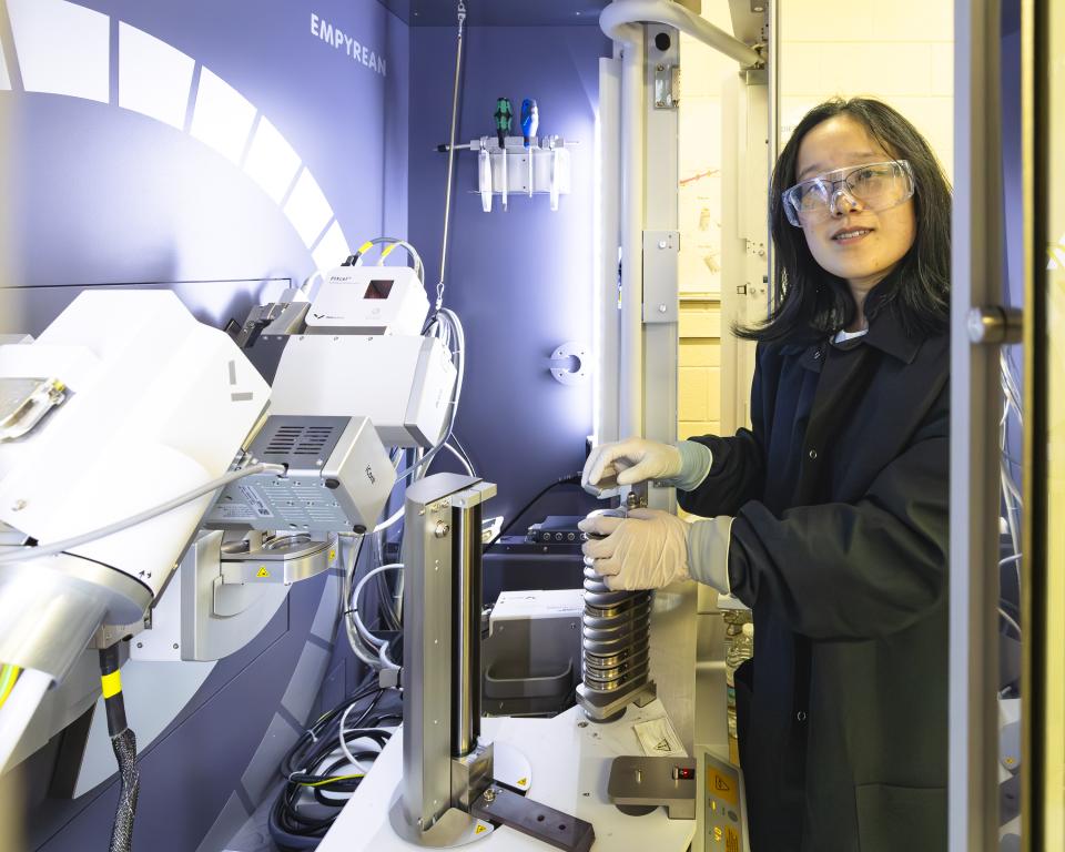 researcher placing batteries into a machine for examining them