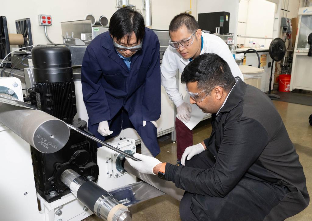 ORNL scientist Zhijia Du, white coat, former ORNL scientist Jianlin Li, blue coat, and Ateios CEO Rajan Kumar inspect battery components during a pilot production run. Credit: Kurt Weiss/ORNL, U.S. Dept of Energy