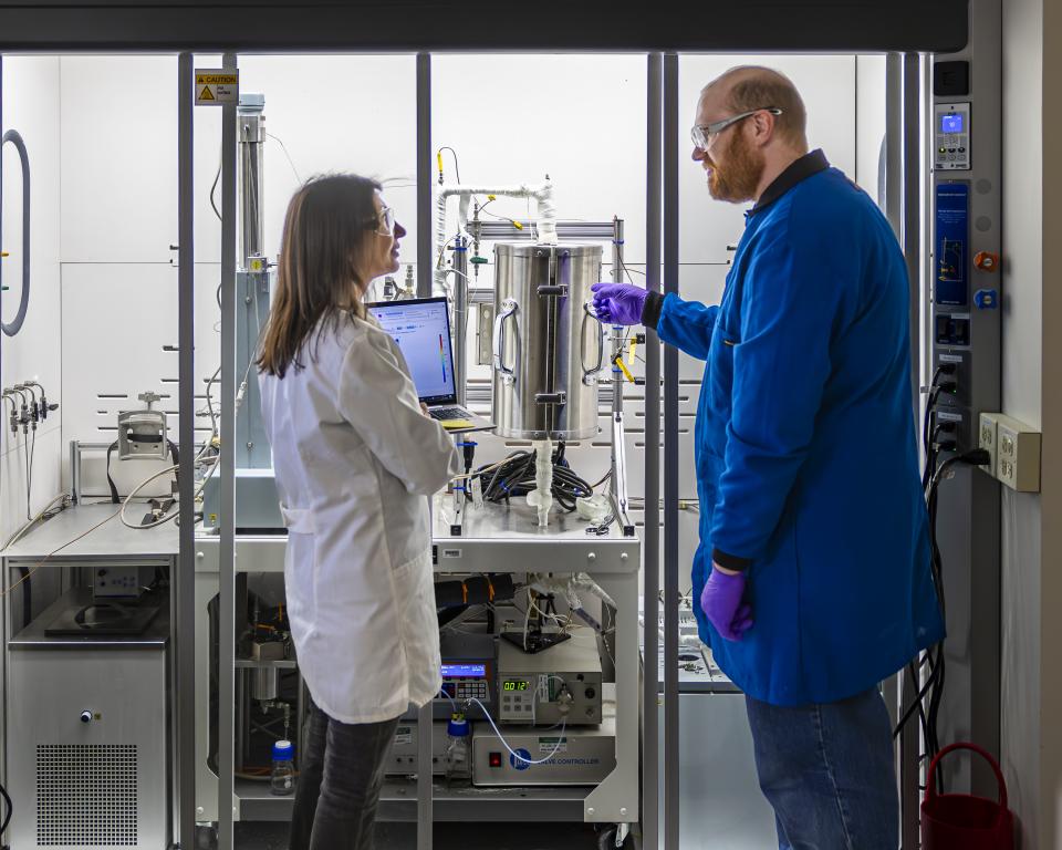 ORNL researcher Canan Karakaya provides computational modeling to ORNL colleagues, including Stephen Purdy, who is preparing experiments with a methanol reactor in the laboratory. Credit: Carlos Jones/ORNL, U.S. Dept. of Energy