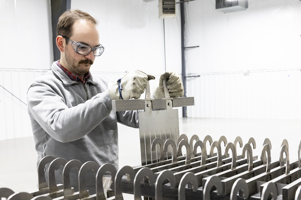 SkyNano’s Stan Hunter selects an electrode to load into the molten salt electrochemical reactor. Credit: Carlos Jones/ORNL, U.S. Dept. of Energy