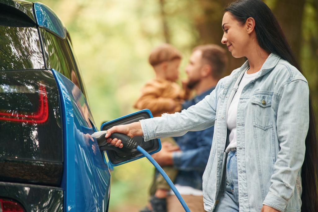 Woman charging electric vehicle
