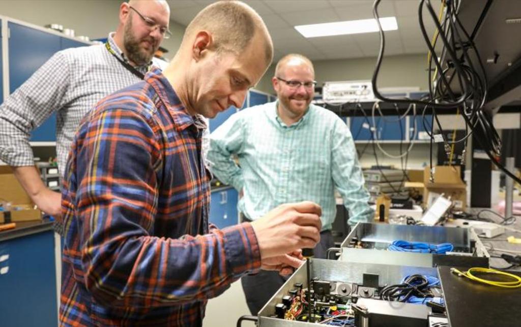 ORNL quantum researchers, from left, Brian Williams, Phil Evans, and Nick Peters work on their quantum key distribution system. 
