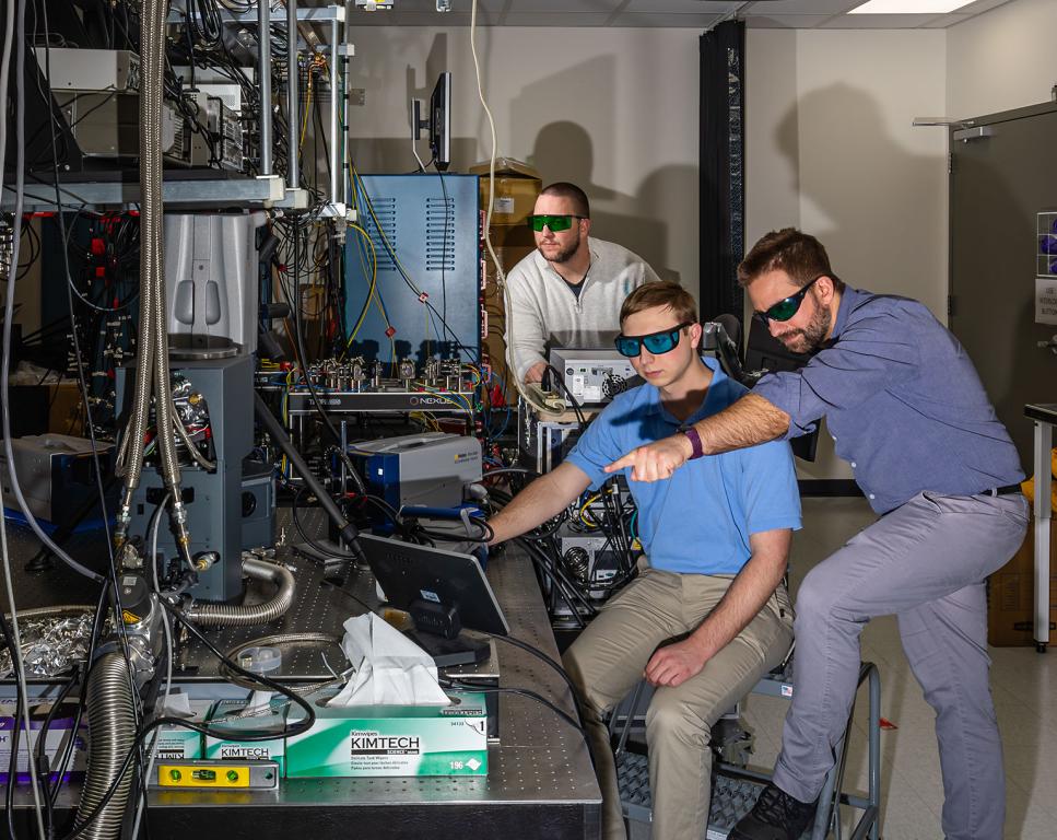 From left, J.D. Rice, Trevor Michelson and Chris Seck look at a monitor in Seck's lab. The three are wearing safety glasses to protect against the laser beams used by the scanning vibrometer, which is helping Seck quantify vibration of an appliance in his lab. Carlos Jones/ORNL, U.S. Dept. of Energy