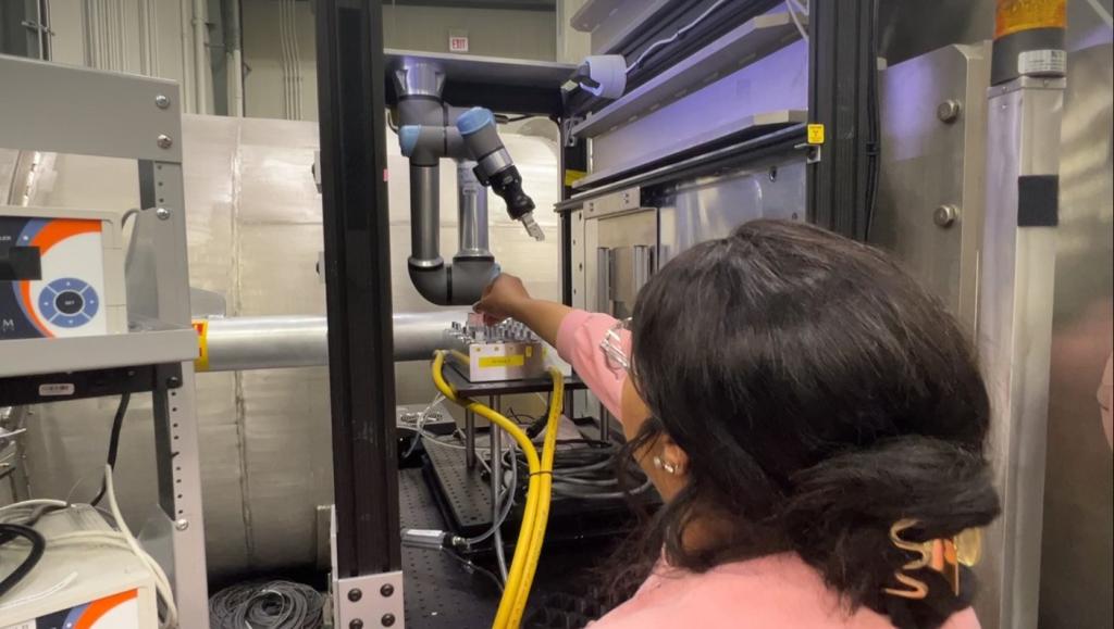 ORNL researcher Felicia Gilliland loads experiment samples into position for the newly installed UR5E robotic arm at the BIO-SANS instrument. The industrial-grade robot changes samples automatically, reducing the need for human assistance and improving sample throughput. Credit: Jeremy Rumsey/ORNL, U.S. Dept. of Energy