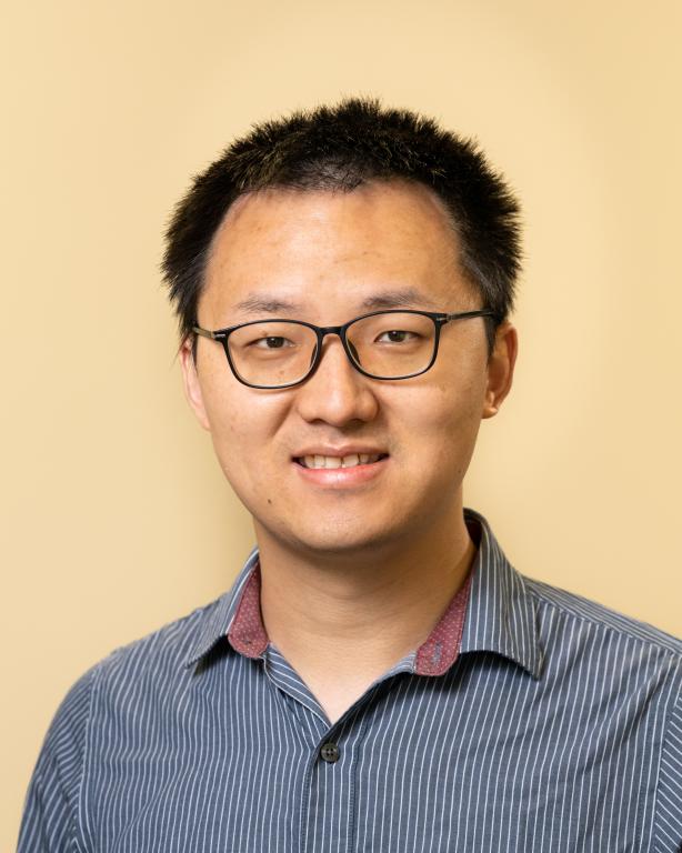 Man in glasses smiles for a photo
