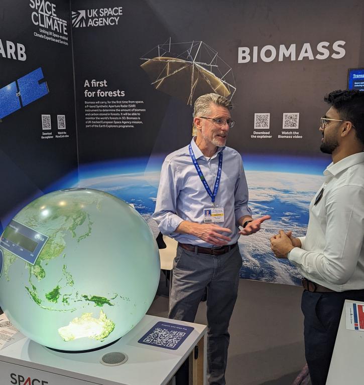 two people talking beside a globe