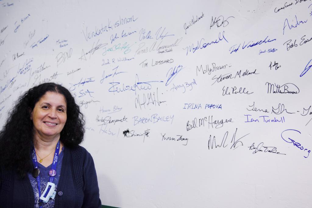 ORNL’s Hassina Bilheux stands before names of staff who have worked on the Spallation Neutron Source’s latest addition, the Versatile Neutron Imaging Instrument, or VENUS.