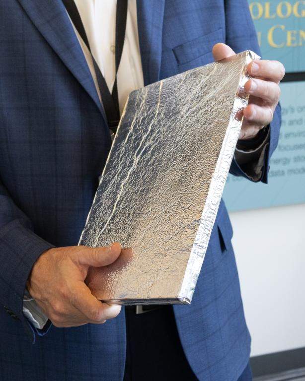 Mike Paulus holds a vacuum insulation panel equipped with the self-healing barrier film.