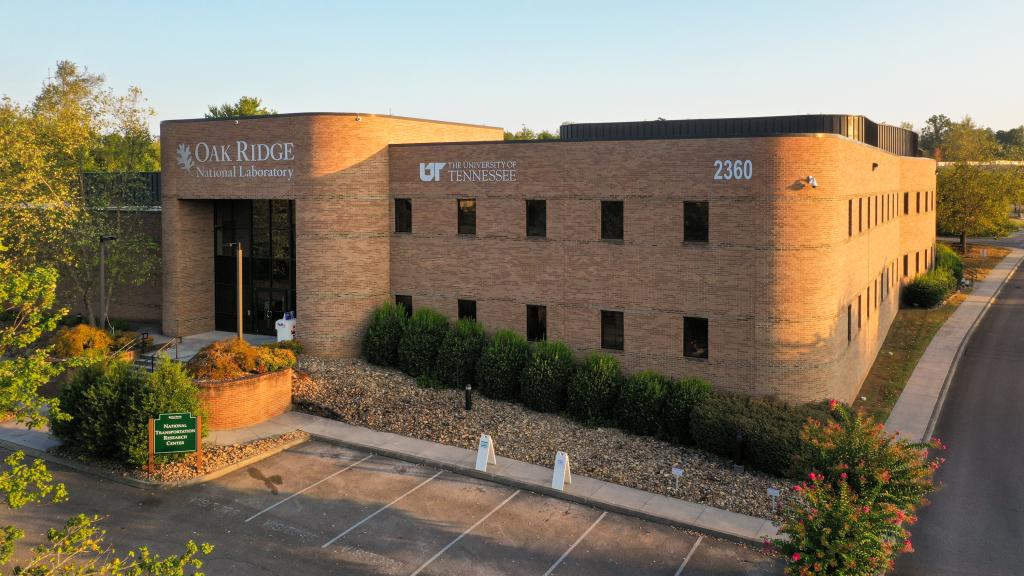 brick building in morning sunlight, the ORNL logo is prominently displayed on a sign on the front of the building