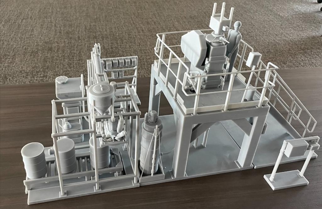 Grey model of a 3D printed system that is small like a table top version of a facility