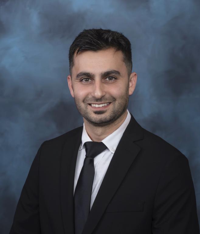 Emrullah Aydin, an ORNL research is posing for a headshot in a black suit with black tie