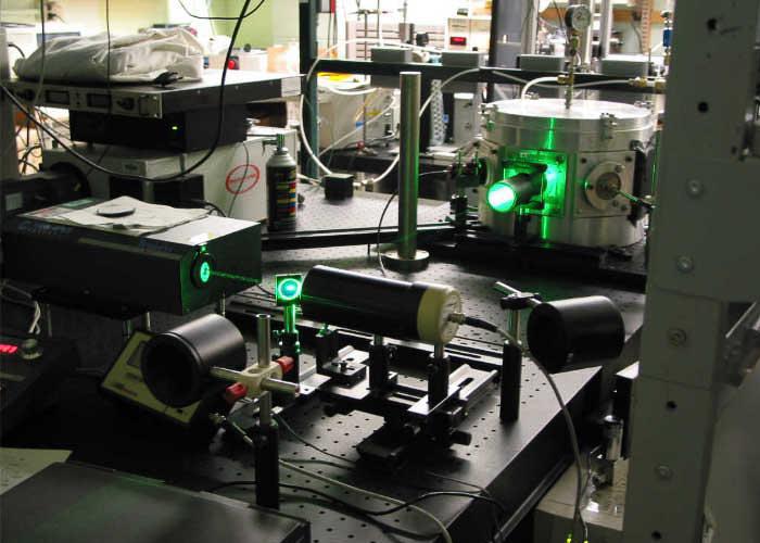Laser equipment and optical devices on an experiment table in a scientific research laboratory.