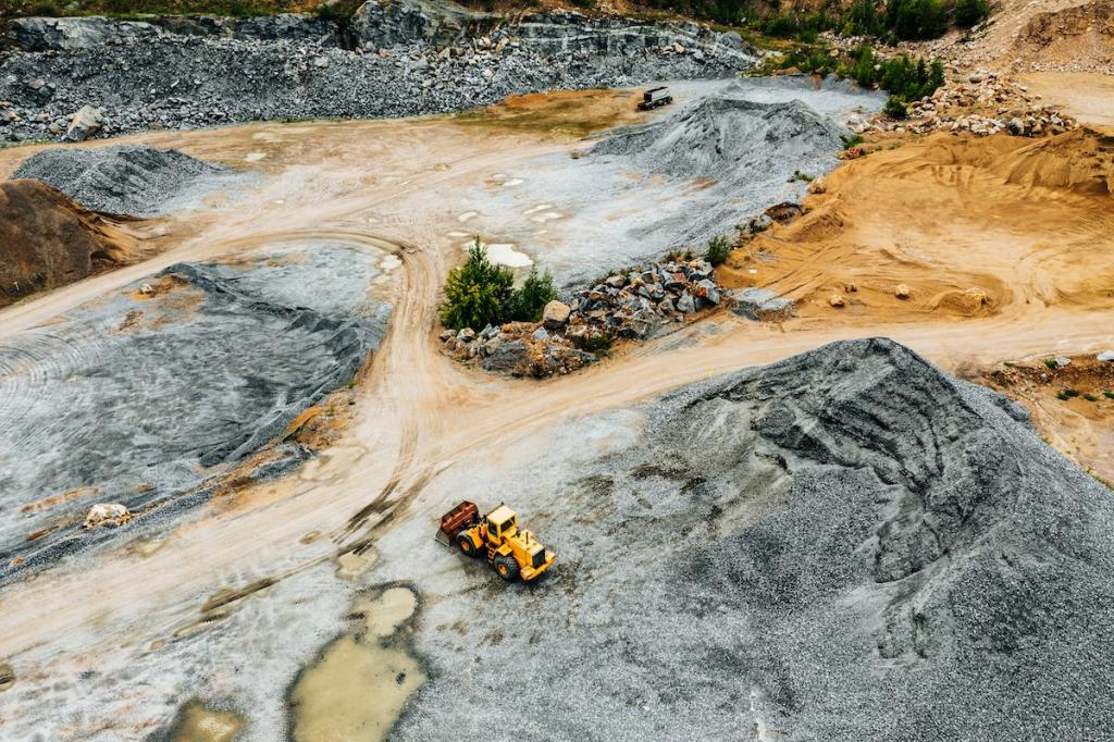 Aerial view of Truck excavator in open sand quarry rubble. Image from Envato