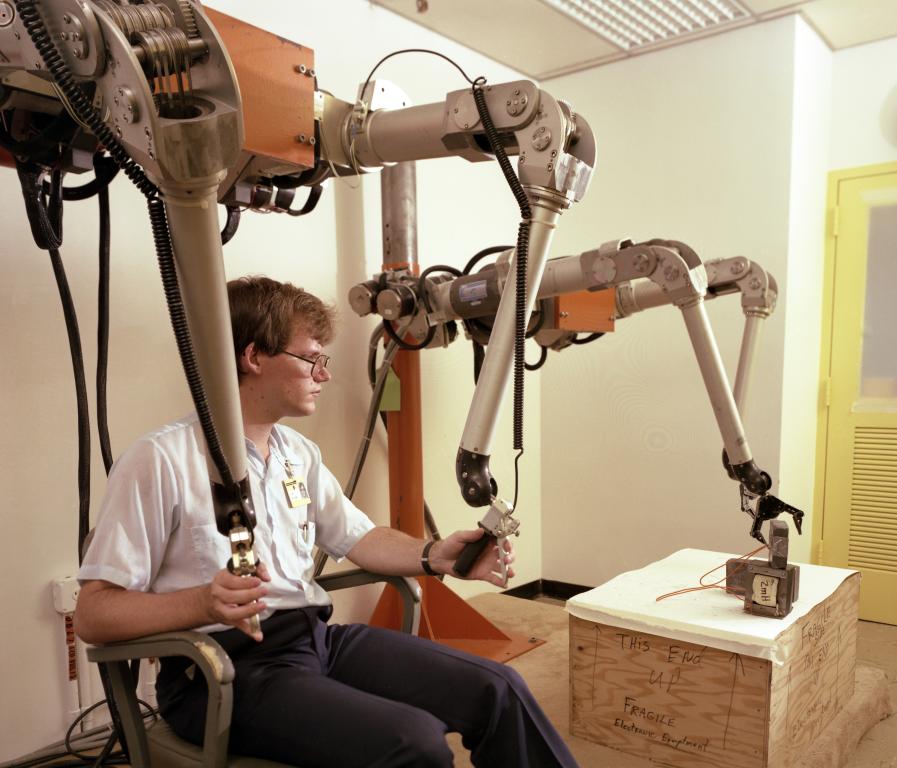 During his first year at ORNL in 1984, Stephen Killough demonstrated robotic manipulator arms he helped develop for use in nuclear research. Credit: ORNL/U.S. Dept. of Energy
