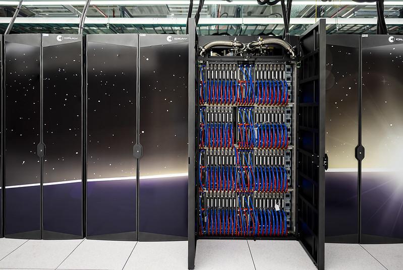 Two cabinets of ORNL's Frontier supercomputer are open to show the blue and red cords on the inside.