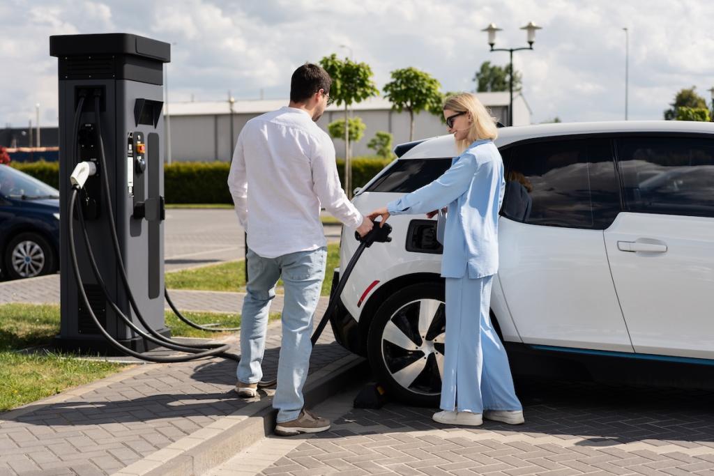 Couple charging electric car at station on sunny day. Image from Envato