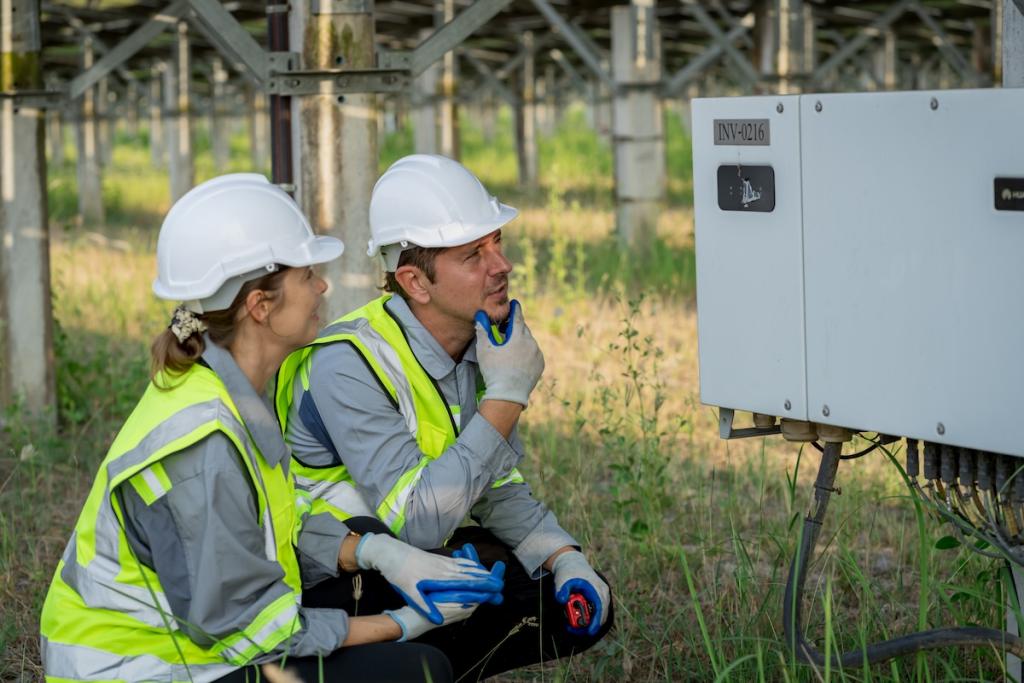 Electrical engineer on solar farm with large structure . Image from Envato