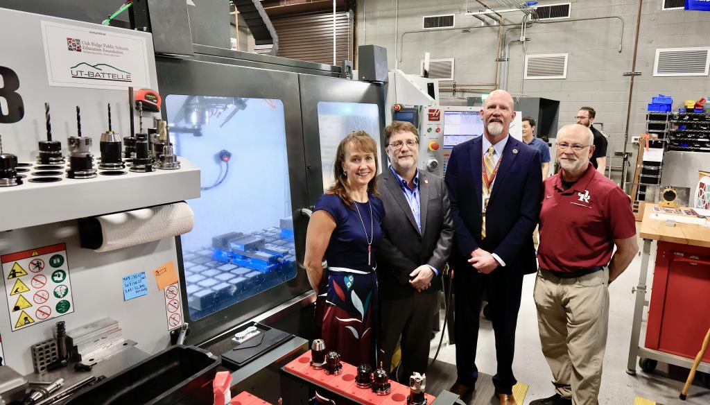 Leadership from ORNL and Oak Ridge High School pose for a photo in front of the 3D printing machine that UT-Battelle donated.