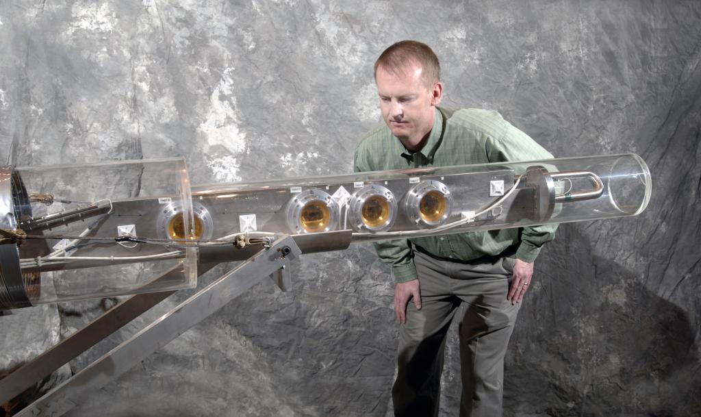 ORNL researcher Van Graves examines a transparent cylindrical device he developed and tested at CERN in 2007 to demonstrate that a jet of liquid mercury could serve as a target for a neutrino factory or muon collider.