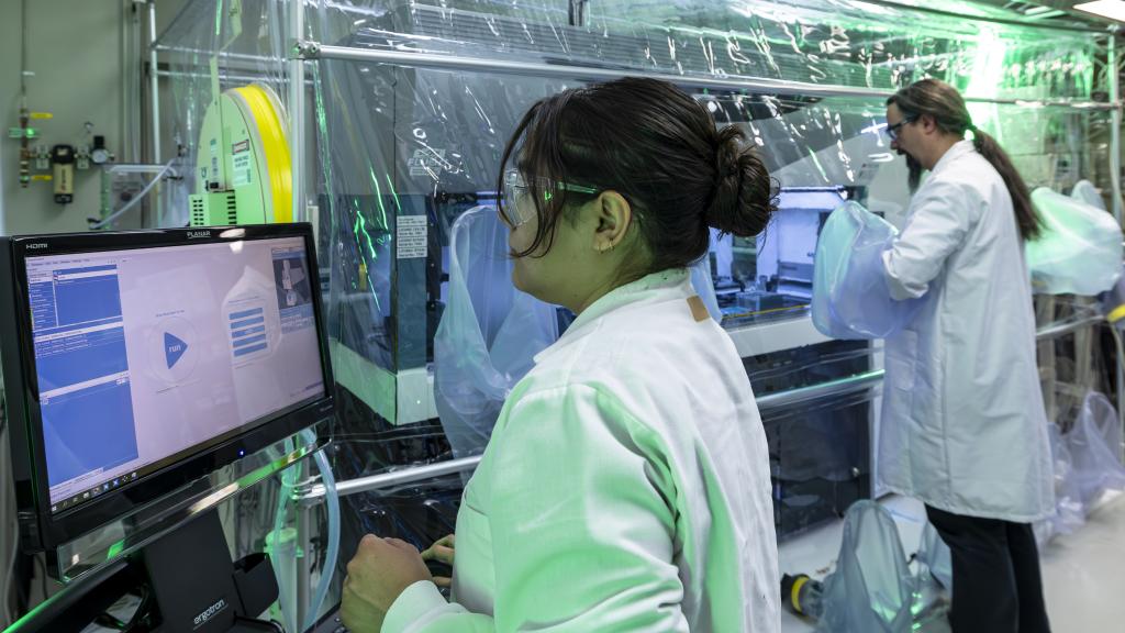 two researchers in white lab coats in a high-tech microbial phenotyping laboratory
