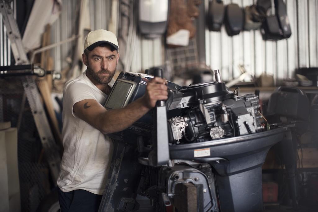 Mechanic working on boat engine in a workshop. Image from Envato