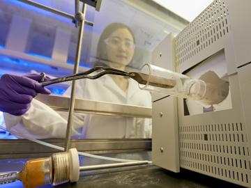 ORNL’s Huiyuan Zhu places a sample of boron nitride, or “white graphene,” into a furnace as part of a novel, nontoxic gas exfoliation process to separate 2D nanomaterials.