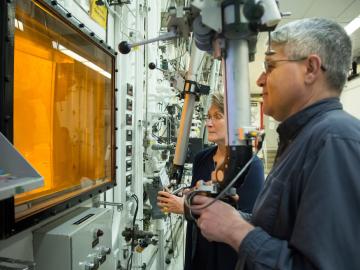 Radiochemical technicians David Denton and Karen Murphy use hot cell manipulators at Oak Ridge National Laboratory during the production of actinium-227.