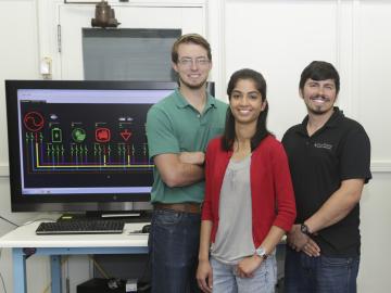 Ben Ollis, Ishita Ray, and Phil Irminger in a Power and Energy Systems group laboratory with SI-GRID components.