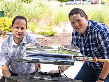 From left, Radu Custelcean and Neil Williams of Oak Ridge National Laboratory used a solar-powered oven to generate mild temperatures that liberate carbon dioxide trapped in guanidine carbonate crystals in an energy-sustainable way.