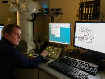 In ORNL’s Low Activation Materials Development and Analysis Laboratory, Field makes use of a transmission electron microscope to examine a sample made with a focused ion beam. He investigates the defects produced in a FeCrAl alloy bombarded with neutrons in HFIR. Credit: Carlos Jones/Oak Ridge National Laboratory, U.S. Dept. of Energy