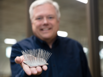 Scott Smith holding machined aluminum part