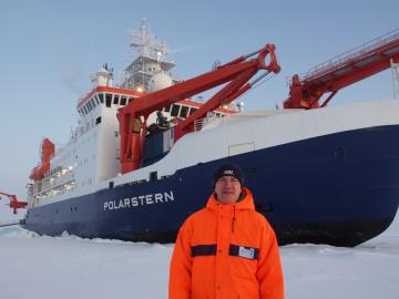 Misha Krassovski, a computer scientist at Oak Ridge National Laboratory, stands in front of the Polarstern, a 400-foot long German icebreaker. Krassovski lived aboard the Polarstern during the first leg of the MOSAiC mission, the largest polar expedition ever. Credit: Misha Krassovski/Oak Ridge National Laboratory, U.S. Dept. of Energy