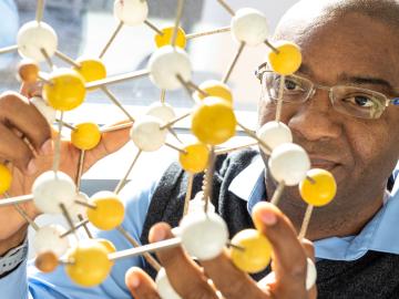 To understand the electronic structures of solids and predict their properties, ORNL’s Valentino Cooper uses density functional theory (DFT), which models how many electrons are in a region rather than where those electrons are. “DFT essentially presents one electron existing in a ‘sea foam’ and tells how dense that foam is,” he said. Credit: Carlos Jones/Oak Ridge National Laboratory, U.S. Dept. of Energy